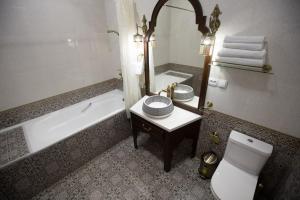 a bathroom with a tub and a toilet and a sink at The Shahar in Tashkent