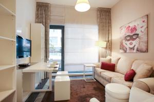 ein Wohnzimmer mit einem Sofa und einem Tisch in der Unterkunft J5 Tower - 1BR Apartment - Allsopp&Allsopp in Dubai