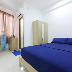 a bedroom with a blue bed and a wooden cabinet at Resting View in Male City