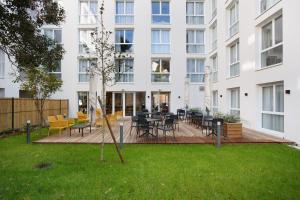 a courtyard with tables and chairs in front of a building at Appart Hotel Odalys City Toulouse Centre Compans Caffarelli in Toulouse