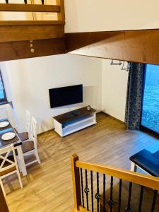 mit Blick auf ein Wohnzimmer mit einem TV und einem Tisch in der Unterkunft Domek Orawski in Zubrzyca Dolna