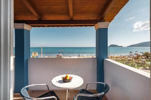 a table and chairs on a balcony with a view of the beach at BLUEWAVES in Laganas