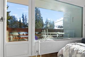 1 dormitorio con ventana grande y vistas a un patio en Appartement cosy et rénové au cœur de la station, en Crans-Montana