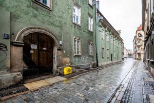 een lege straat met een groen gebouw met een deur bij Rent like home - Ślusarska 13 in Poznań