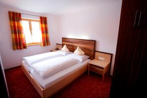 Un dormitorio con una gran cama blanca y una ventana en Residenz Cristallo, en Reit im Winkl