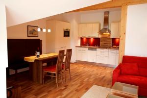 cocina y sala de estar con mesa y sofá rojo en Residenz Cristallo, en Reit im Winkl