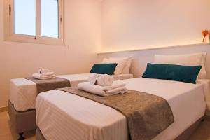 a room with two beds with towels on them at Phaedrus Living - Seaside Deluxe Flat Harbour 106 in Paphos