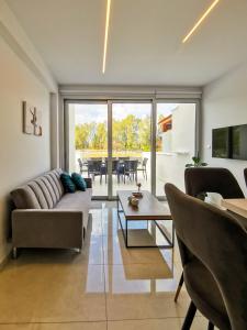 uma sala de estar com um sofá e uma mesa em Phaedrus Living - Seaside Deluxe Flat Harbour 107 em Pafos