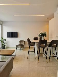 a living room with a table and chairs at Phaedrus Living - Seaside Deluxe Flat Harbour 107 in Paphos