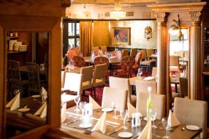 a dining room with tables and chairs and a mirror at Park Hotel Vossevangen in Vossevangen