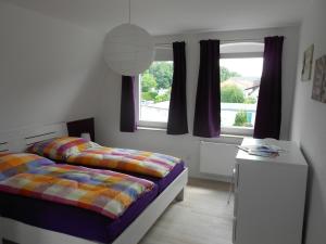 a bedroom with a bed and a desk and a window at Ferienwohnungen Haus Glückauf in Kölpinsee