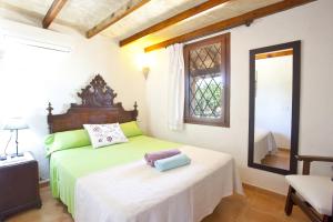 a bedroom with a bed and a window and a mirror at Villa Son Fullos in Santa Margalida