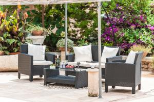 a patio with chairs and a table and an umbrella at Villa Son Fullos in Santa Margalida