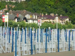 a bunch of white chairs are lined up on the beach at Hotel Ezeiza in San Sebastián