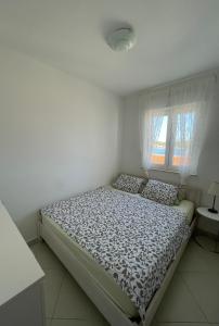 a bed in a white room with a window at Apartment Ana in Trogir