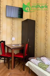 a room with a table and chairs and a tv at Hostel Noclegi Chorzow in Chorzów