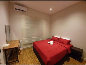 1 dormitorio con cama con sábanas rojas y escritorio en Puri Mediterania Semarang, en Kalibanteng-lor