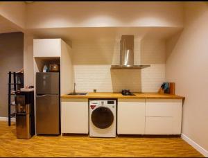 a kitchen with a washing machine and a refrigerator at Puri Mediterania Semarang in Kalibanteng-lor