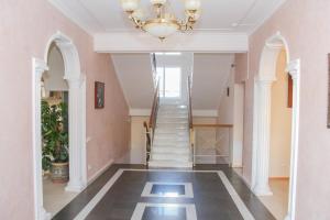 a hallway with a staircase and a chandelier at Семейный отель "Виноградный" in Sochi