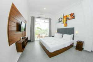 a bedroom with a large bed and a television in it at Scenic Bay Weligama in Weligama