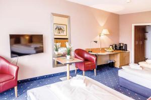 a hotel room with a bed and a desk at Apartment Seeblick am Bocksberg - Hahnenklee "Vier Jahreszeiten" in Hahnenklee-Bockswiese
