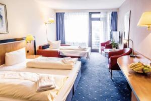 a hotel room with two beds and a desk at Apartment Seeblick am Bocksberg - Hahnenklee "Vier Jahreszeiten" in Hahnenklee-Bockswiese