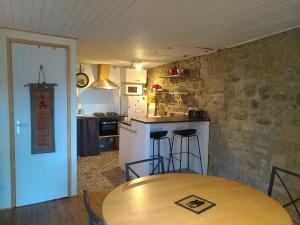 a kitchen with a wooden table and a counter top at gîte de la garde in Prévenchères