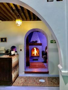 舍夫沙萬的住宿－達達迪奇雷夫摩洛哥傳統庭院住宅，壁炉,位于带拱门的房间