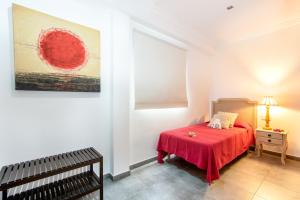 een slaapkamer met een bed met een rode deken bij Apartamento Castello Playa in Can Picafort