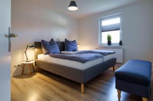 a bedroom with a bed with blue pillows and a window at Fördepause in Flensburg