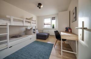 a bedroom with a bunk bed with a desk and a chair at Fördepause in Flensburg