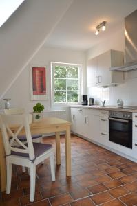 een keuken met een houten tafel en een houten stoel bij Ferienwohnung im Stadthaus - zwei Schlafzimmer in Winsen