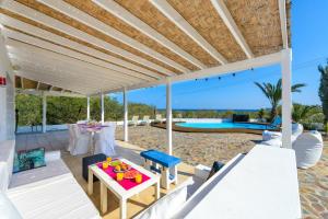 un patio con mesa, sillas y piscina en Villa Marilena, en Protaras