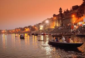 un grupo de personas en barcos en un río por la noche en Maa Vaishno Guest House, en Varanasi