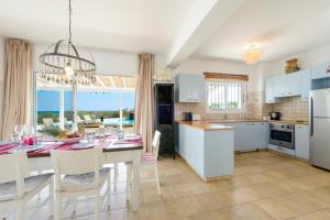 a kitchen and dining room with a table and chairs at Villa Marilena in Protaras