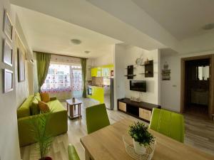 Una sala de estar con una mesa y sillas verdes. en Apartament Summerland Mamaia Nord, en Mamaia