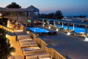 a hotel patio with chairs and a pool at night at The Majestic Hotel in Fira