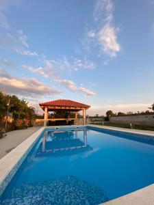 uma piscina com um gazebo ao fundo em Private Villa Miletić em Donje Ogorje