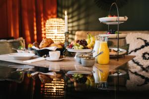 a table with breakfast foods and juice on it at Freilich am See - Gästezimmer in Strausberg