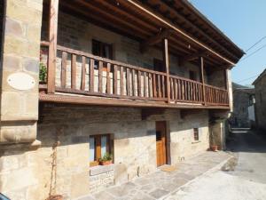 a building with a wooden balcony on top of it at Posada La Braniza in Vega de Pas