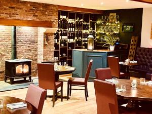 a restaurant with tables and chairs and a fireplace at Oak Tree Inn in Brafferton