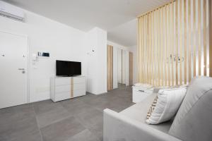 Una sala de estar con un sofá y un televisor. en GetTheKey Lenzi Suites, en Bolonia