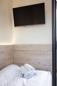 a bed with towels and a flat screen tv at Roatel Schkeuditz A9 my-roatel-com in Schkeuditz