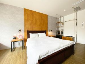 Schlafzimmer mit einem großen Bett mit einem Kopfteil aus Holz in der Unterkunft Taichung Old F Hotel in Taichung