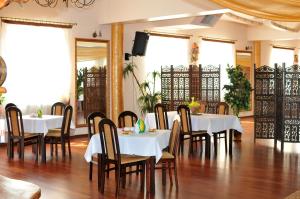 a dining room with white tables and wooden chairs at Hotel Restauracja LORENZO in Stopnica