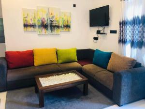 Mirissa Paddy House في ميريسا: غرفة معيشة مع أريكة مع وسائد ملونة