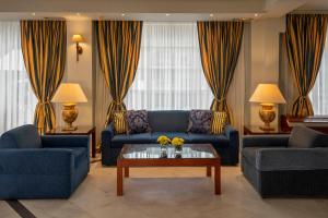 a living room with two blue couches and a coffee table at Hotel Kierion in Karditsa