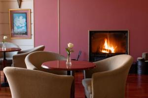 カルディツァにあるHotel Kierionのテーブルと椅子、暖炉が備わる部屋