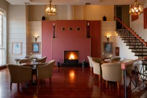 a room with tables and chairs and a fireplace at Hotel Kierion in Karditsa