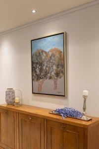 a painting on a wall above a wooden cabinet at Hotel Kierion in Kardítsa